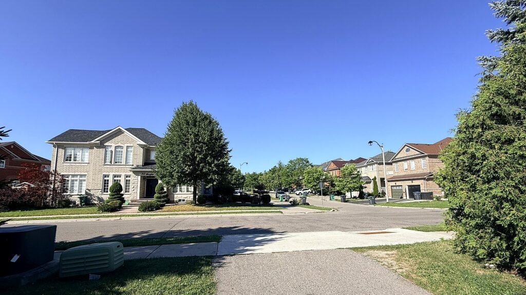 Brampton residential street with detached and semi-detached homes under a clear blue sky